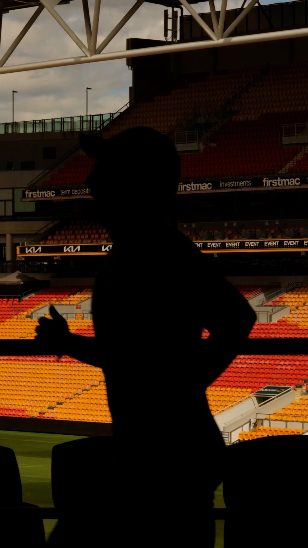 Silhouette against a lit stadium bowl